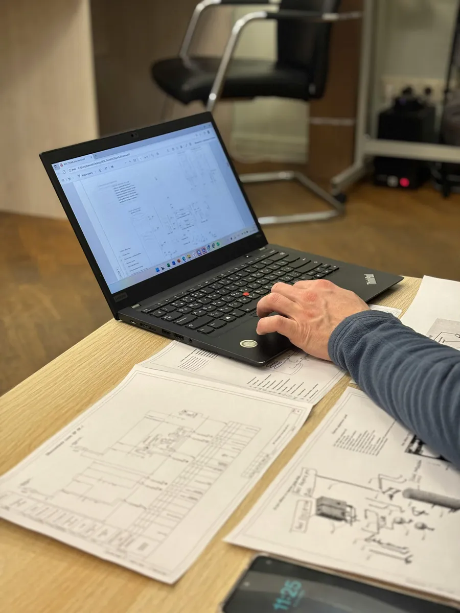 Économiste de la construction analysant un dossier d'appel d'offres BTP à son poste de travail